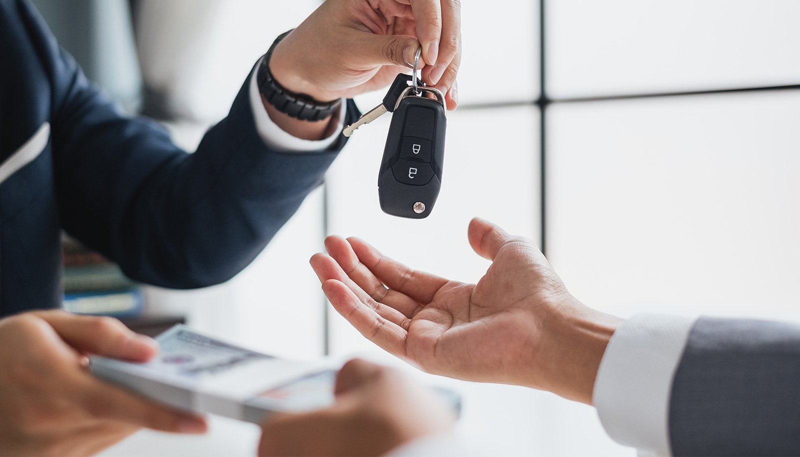 Auto dealer handing car keys to a customer